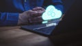 Person using laptop with a glowing holographic cloud with gears and a loading bar Royalty Free Stock Photo